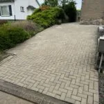Opritreiniging door Group JRS, het verwijderen van vuil, mos en vlekken voor een schone en veilige oprit.