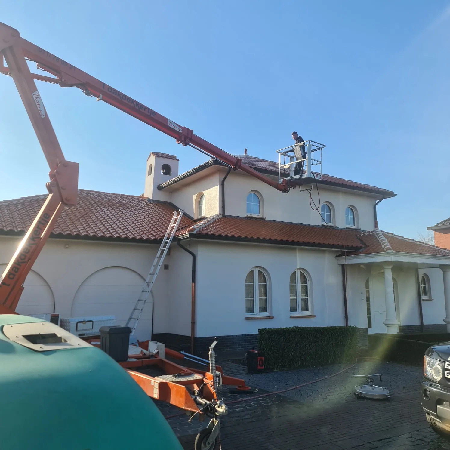 Dakreiniging van een villa in Sint-Truiden door Group JRS, het verwijderen van mos, vuil en aanslag voor een schoon en goed onderhouden dak.